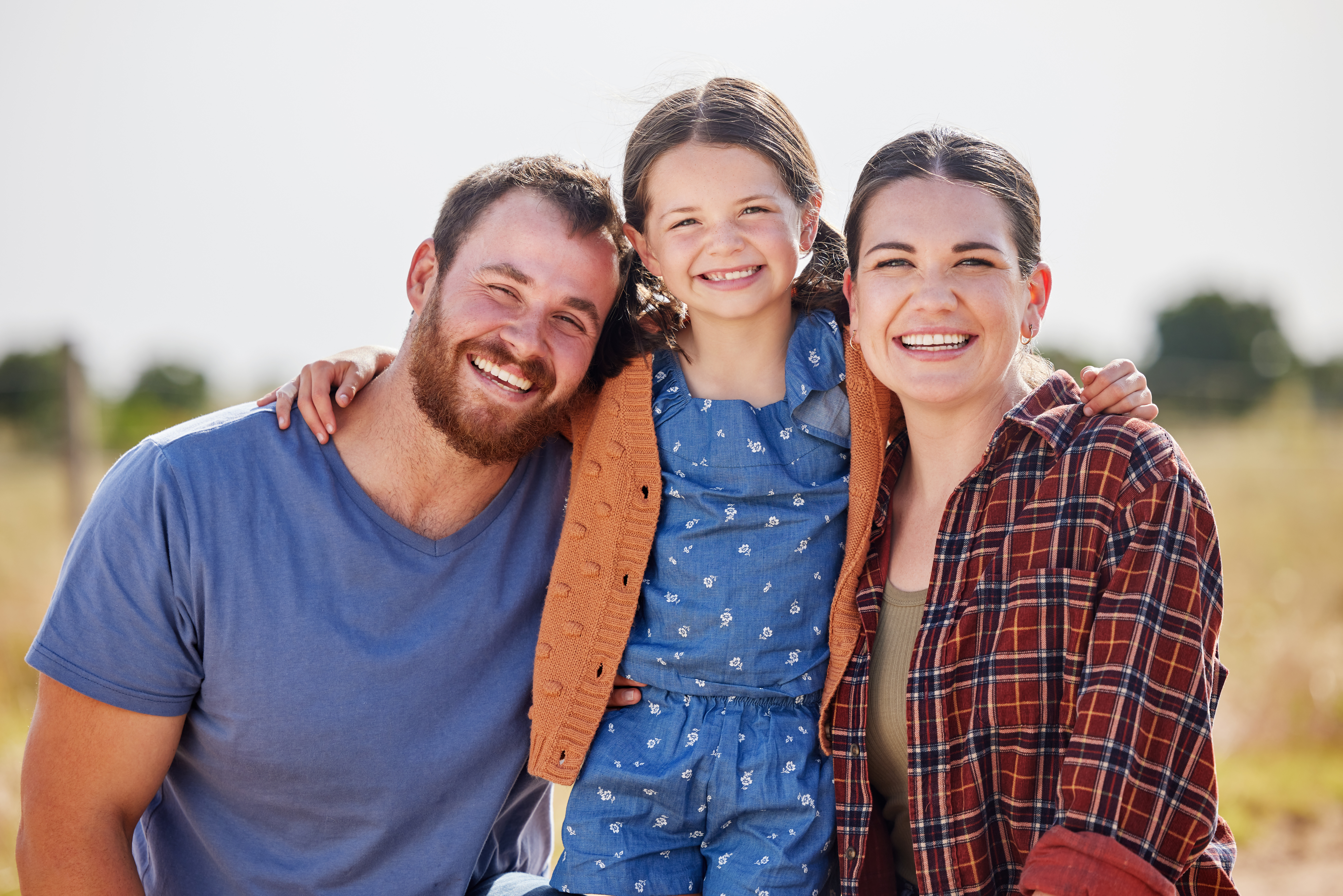 A happy family smiles together in a peaceful rural setting in Perry Hall, MD