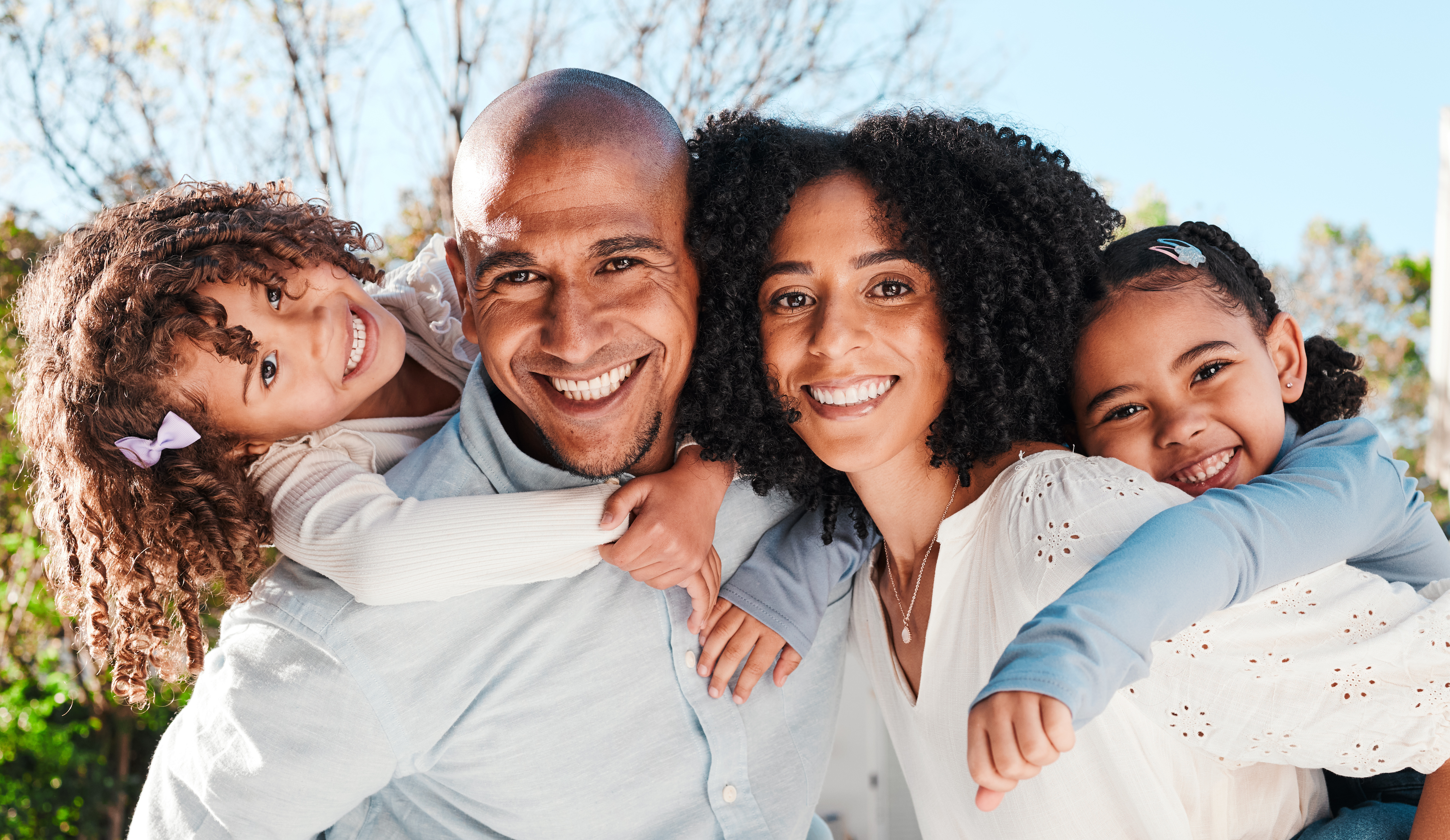 A happy family smiling together outdoors in the bright sunlight in Essex, MD
