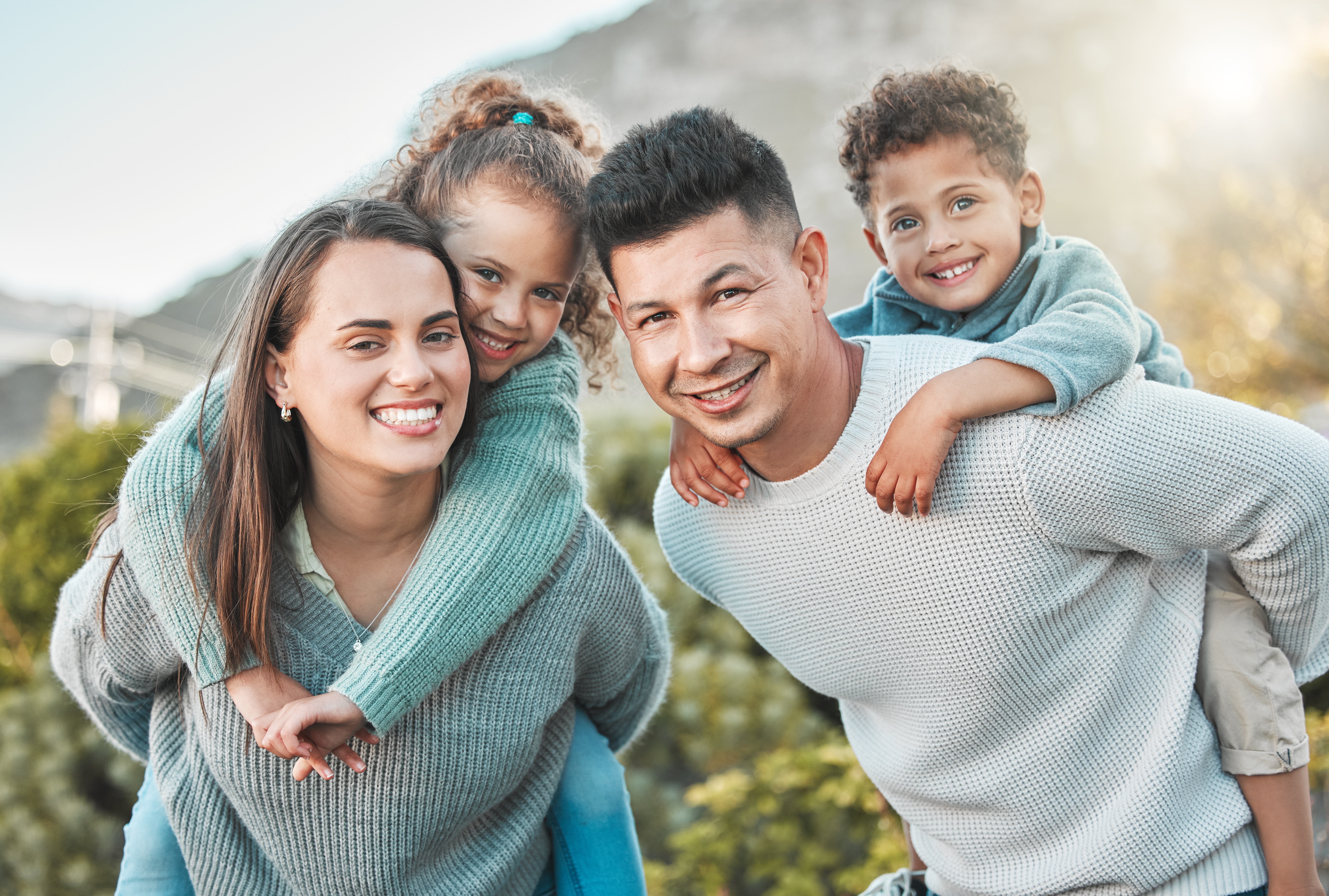 A happy family smiling together in a lush, natural park setting in Williamsburg, VA
