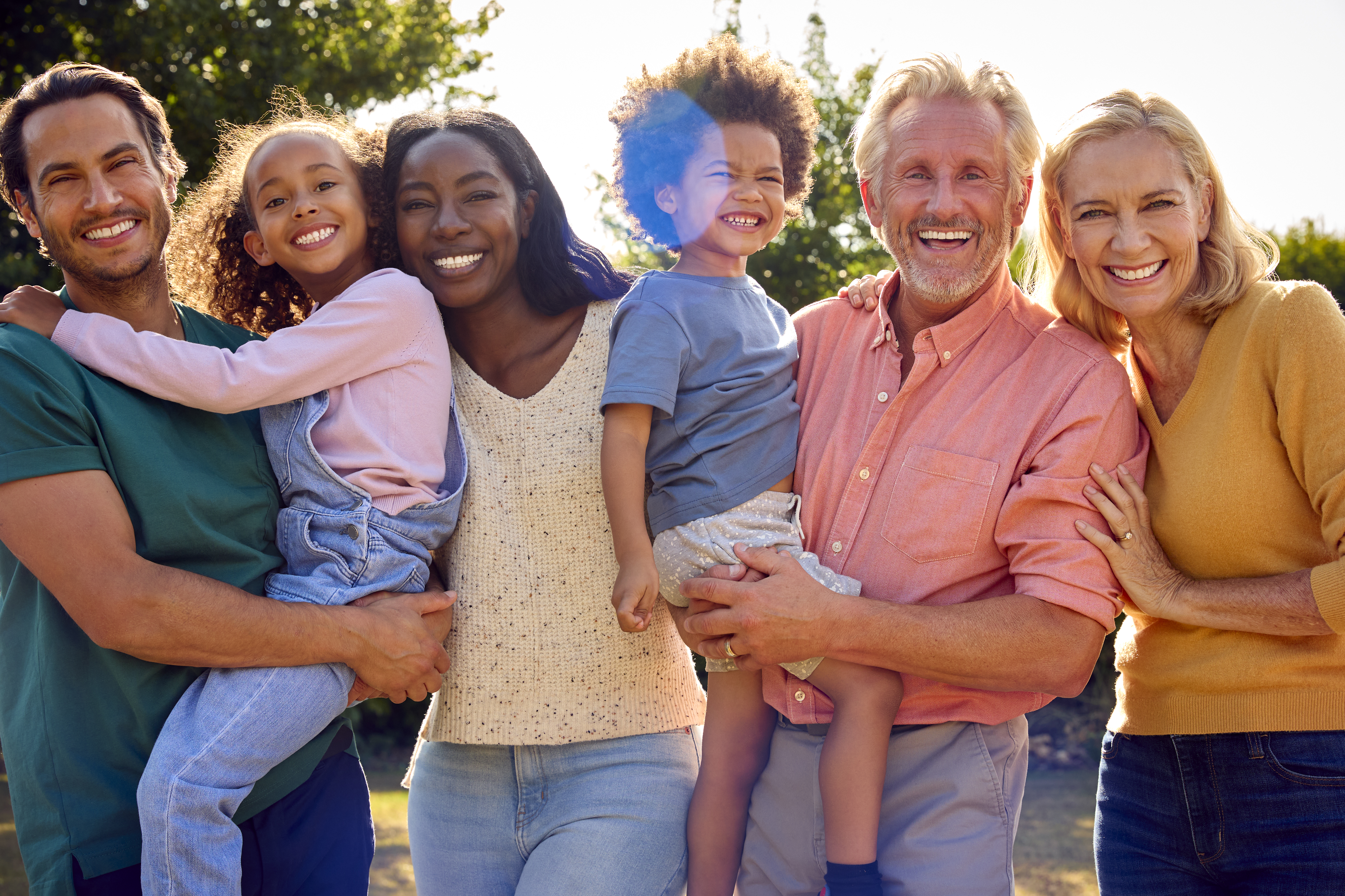 A multi-generational family smiling together in their Gaithersburg, Maryland garden
