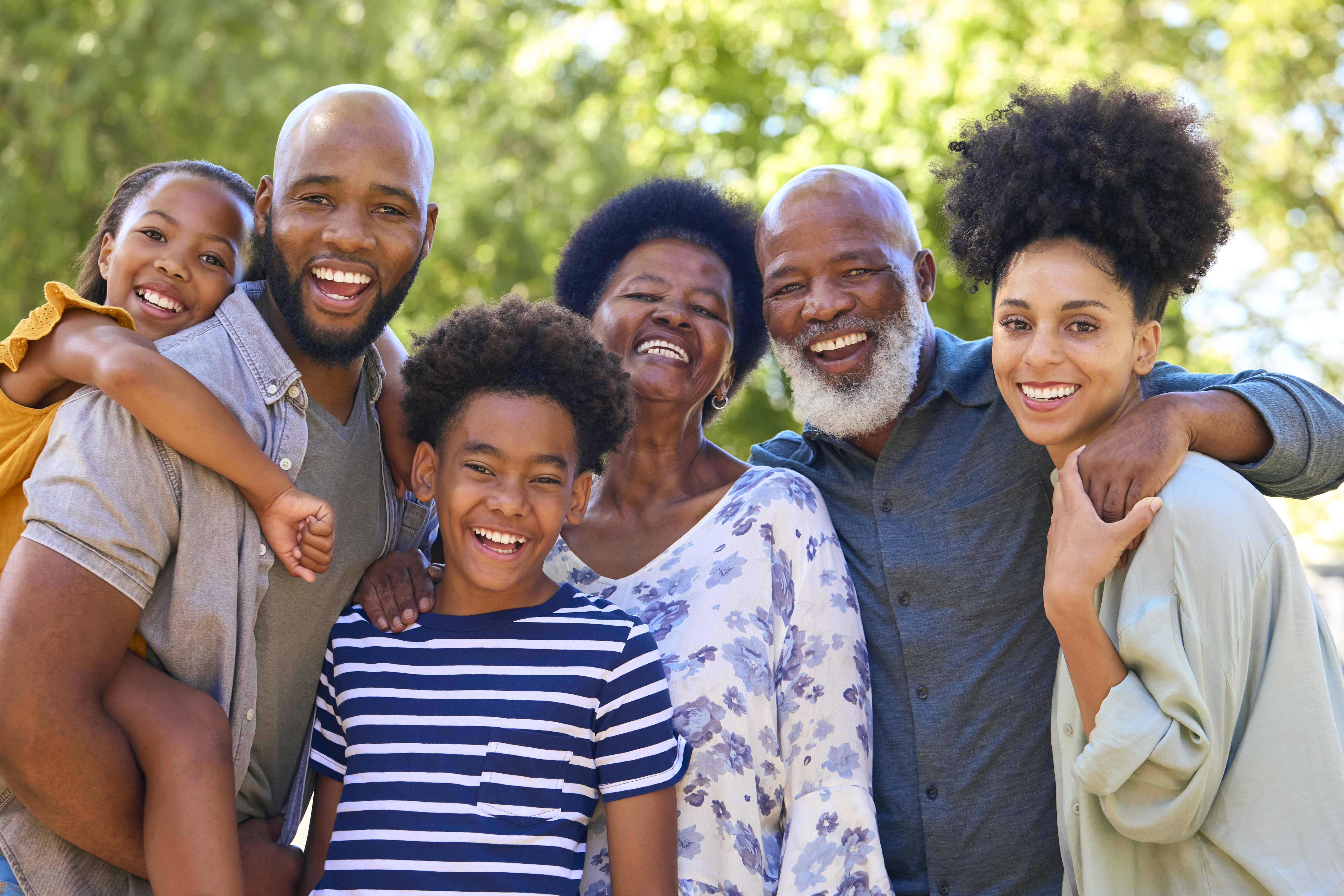 A happy multi-generational family standing together outdoors in a Norfolk, VA residential neighborhood