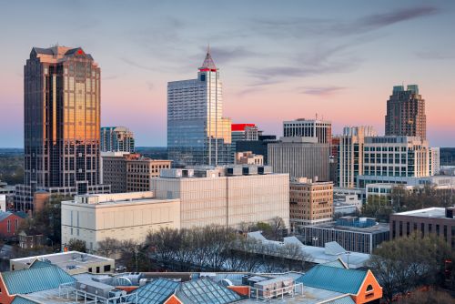 Raleigh downtown skyline and growing suburban housing market across the Triangle region