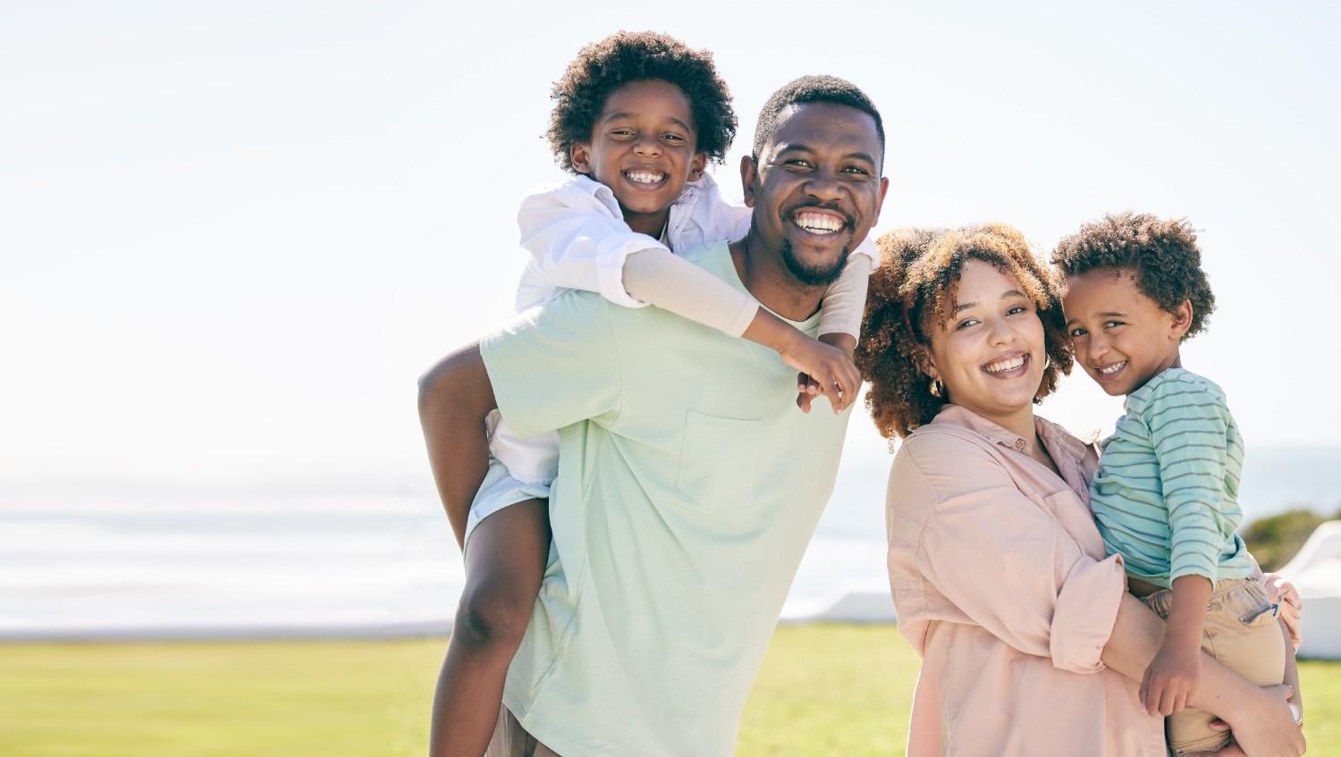 A happy Black family smiling together for a portrait at a scenic location in Petersburg, VA