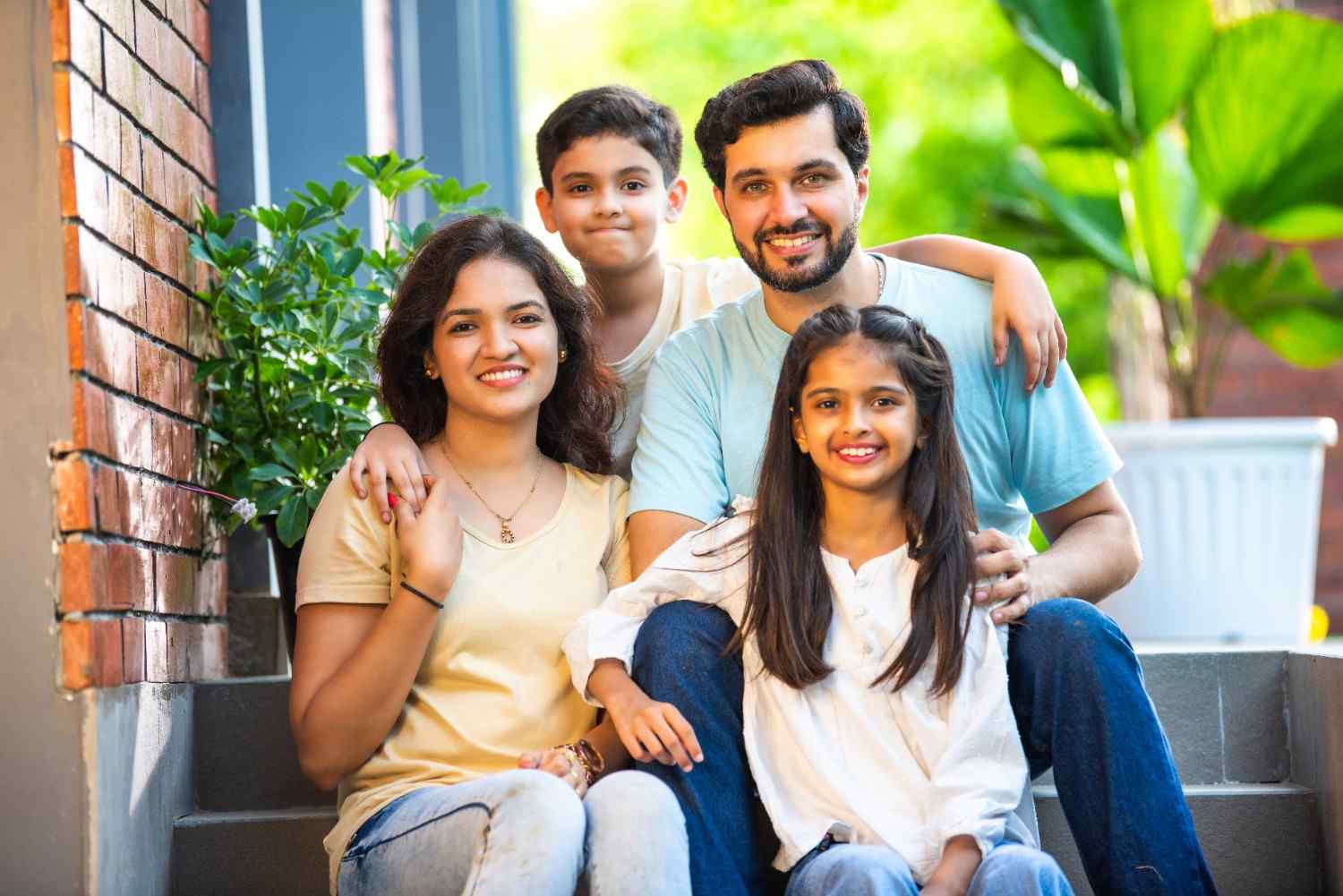 A smiling family relaxing together on a lush green lawn on a sunny day in Edgewood, MD