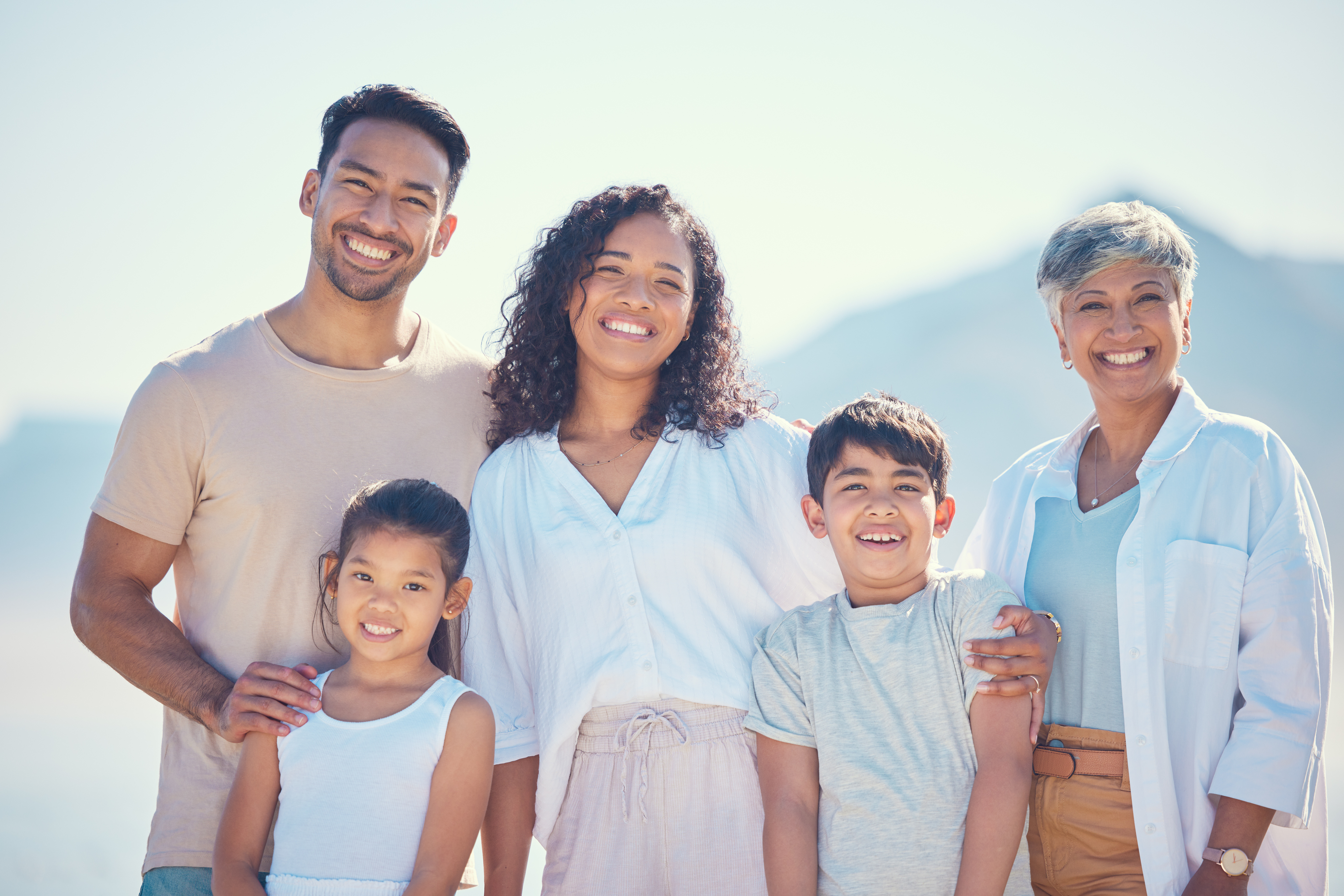 A happy, smiling family enjoying time together outside in the bright sunlight in Catonsville, MD