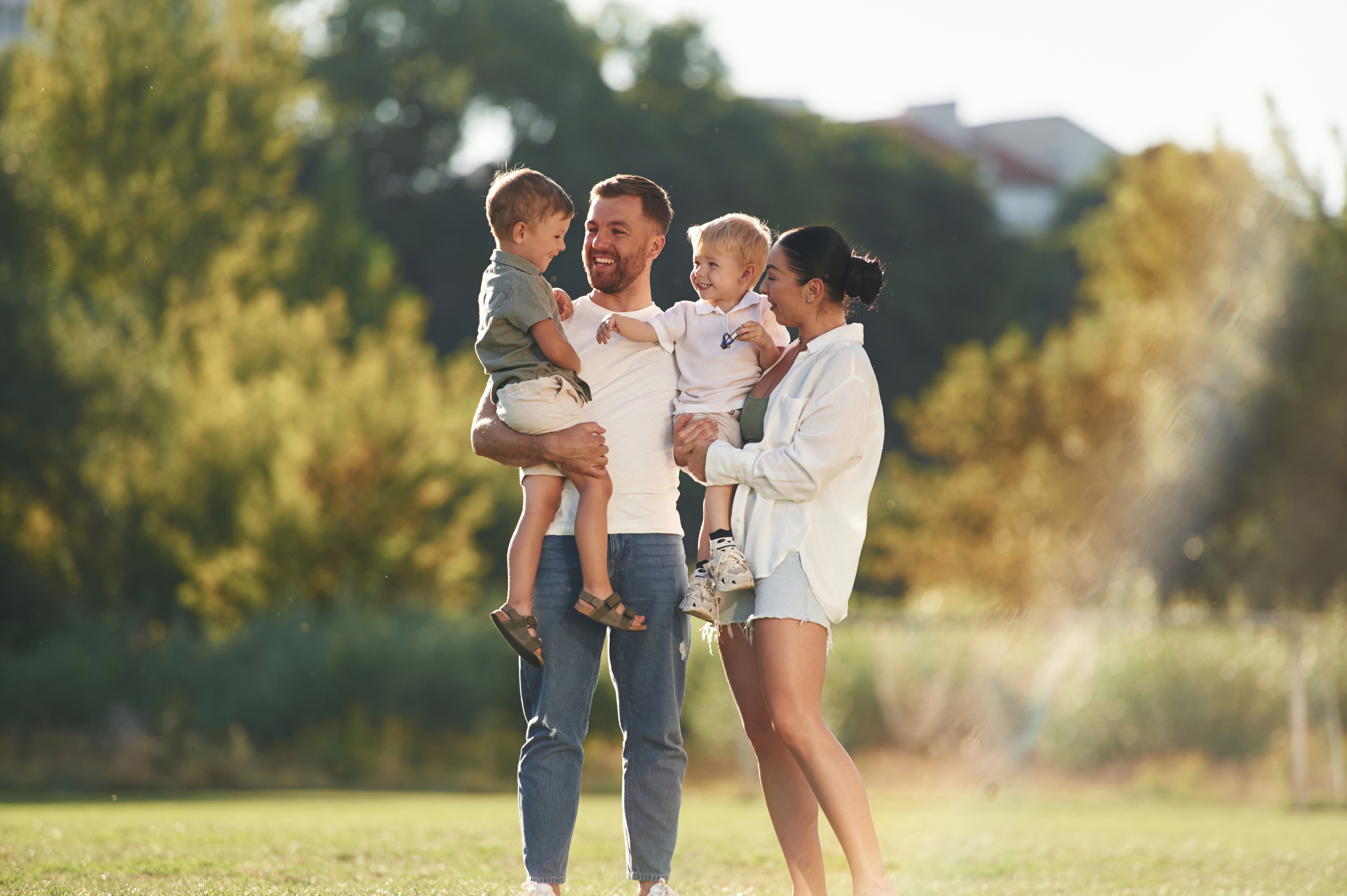 A happy family with two young children standing in front of their home in a Manassas, VA neighborhood