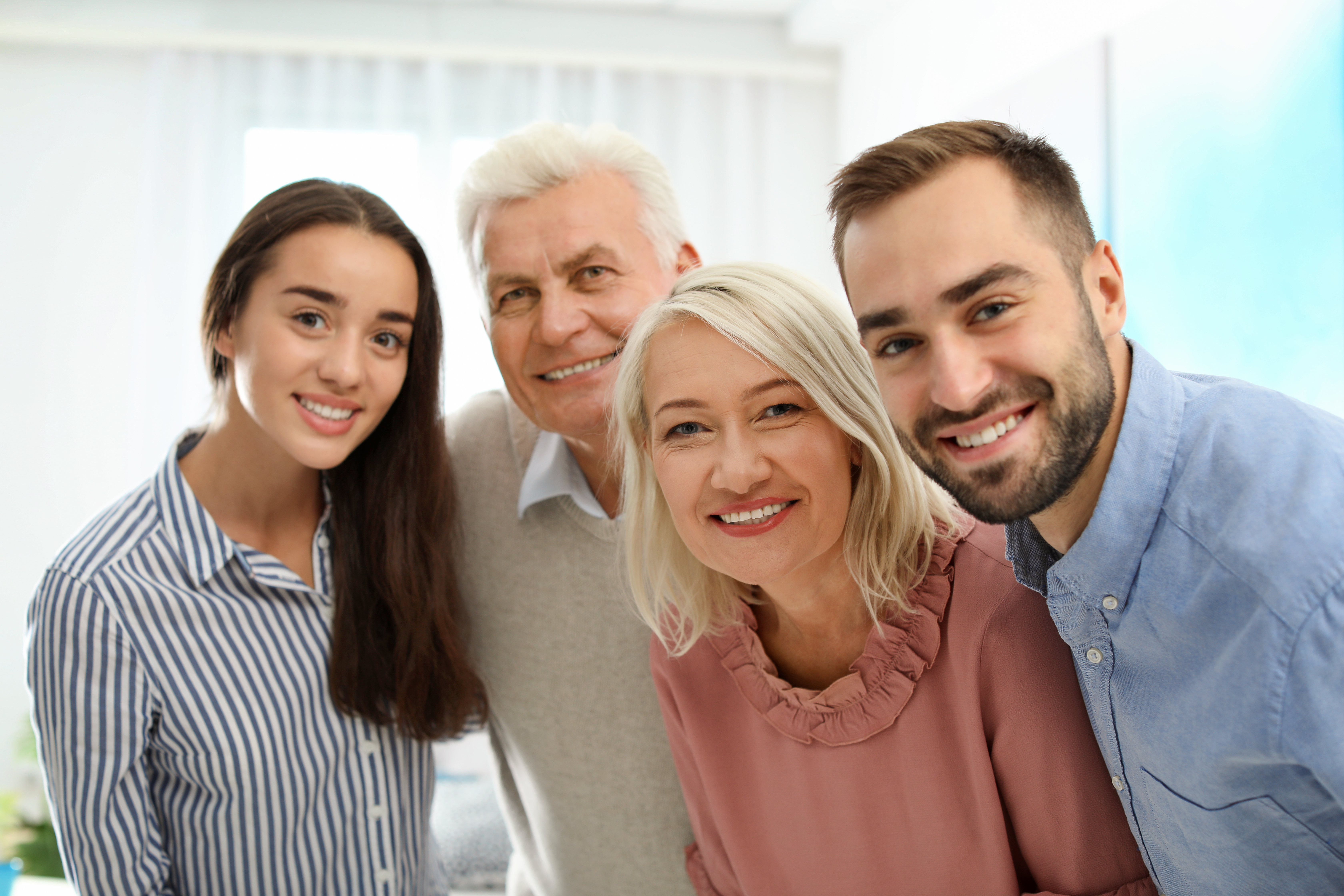 A happy family smiling together for a portrait on a scenic beach in Portsmouth, VA
