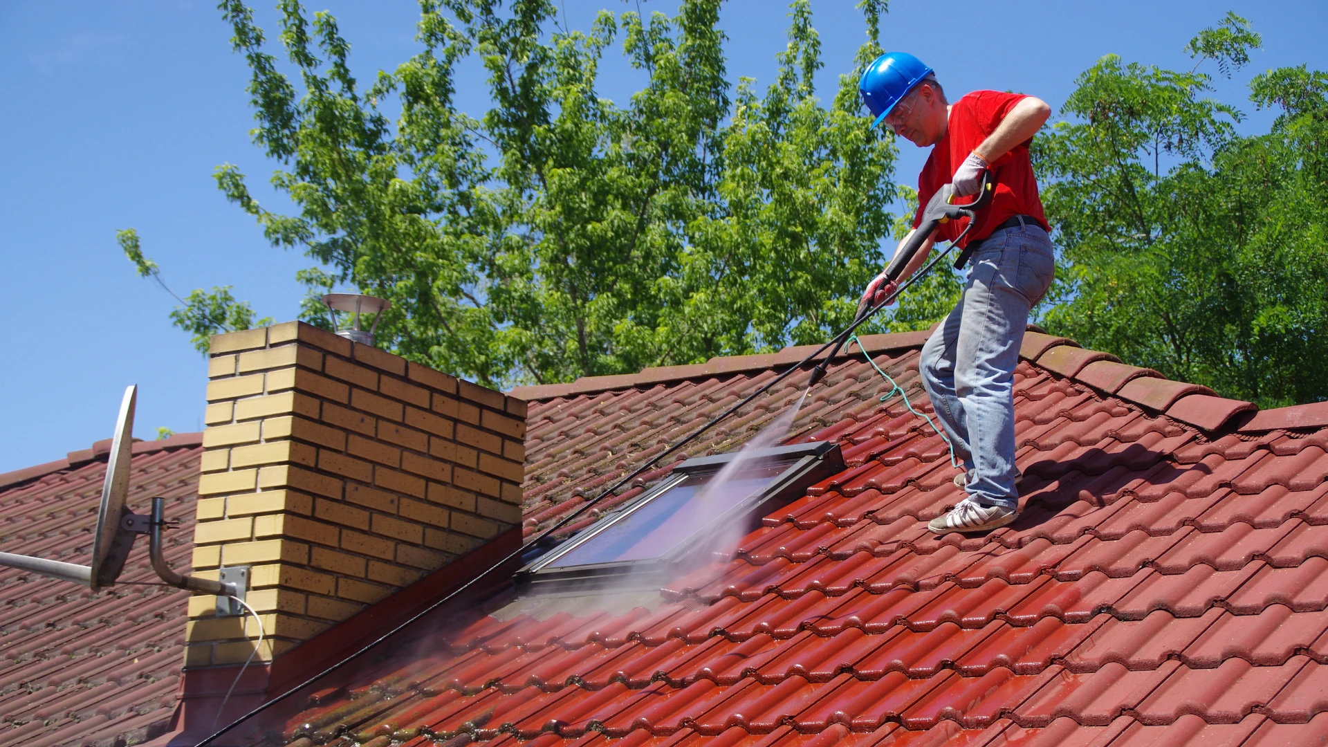 Man powerwashing roof
