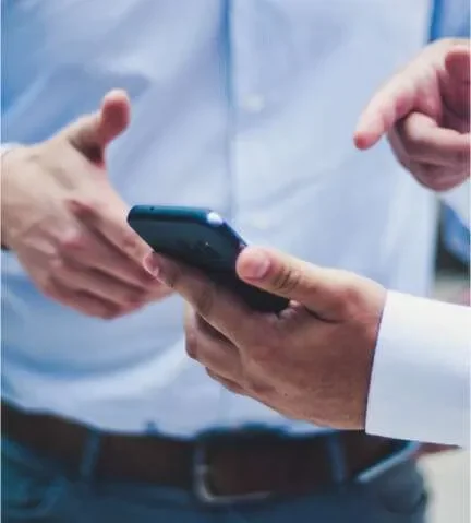 men talking and pointing at his phone