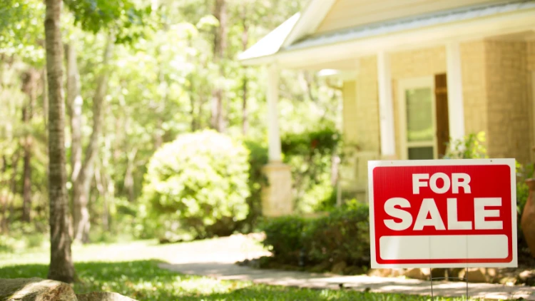 for sale sign in front of house