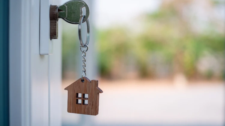 key with house-shaped keychain in door lock