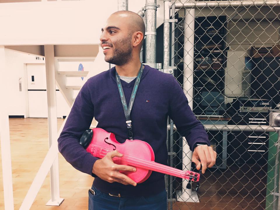 A NASA employee holding a pink 3d printed violin