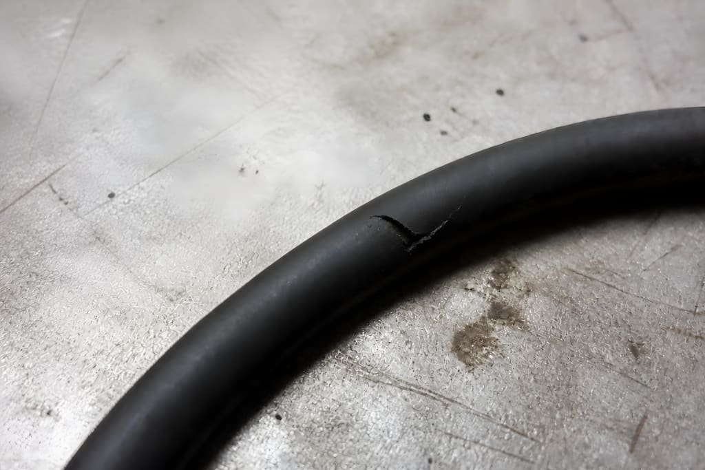 KI-generiertes Symbolbild nach einer realen Kundenanwendung, Details aus Vertraulichkeitsgründen verändert. Lokale Kerbe mit teilweise abgelöster Gummilippe an einem O-Ring nach Montageschaden durch scharfkantiges Werkzeug.