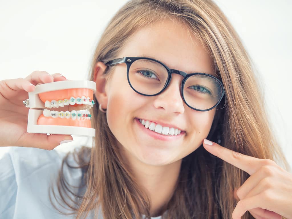 jeune fille tenant une replique de machoire avec bagues