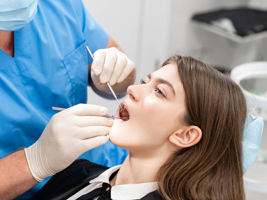 dentiste oscultant femme au fauteuil