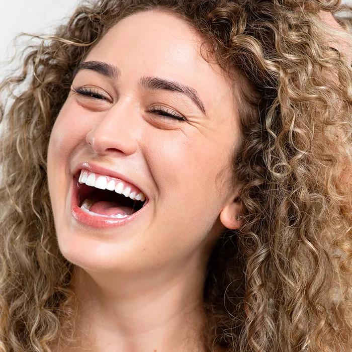 Portrait photo of a woman with curly hair smiling
