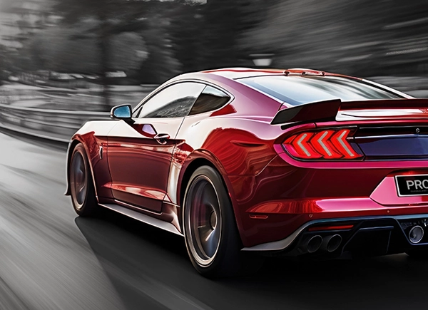 A red high powered car speeding down the road