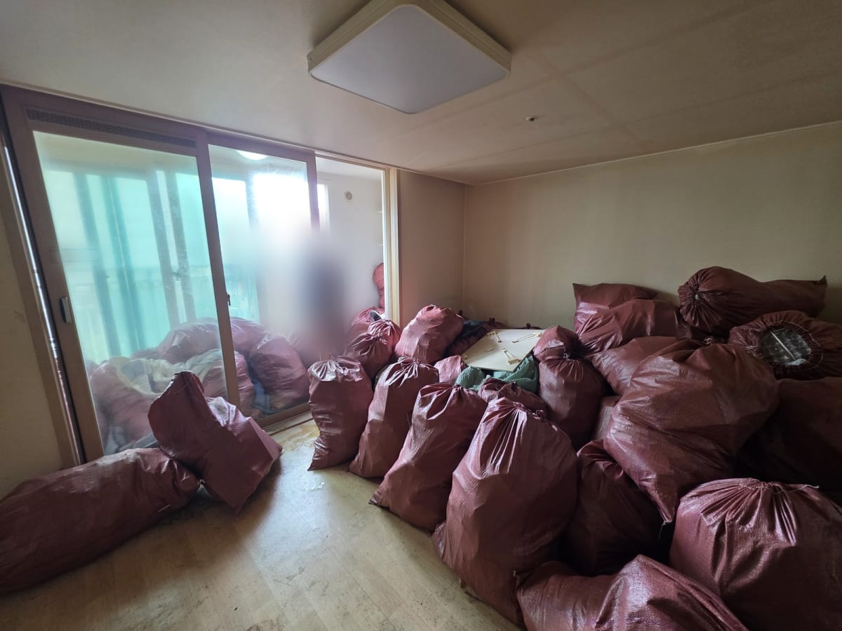 집 안의 짐을 전부 마대에 담아 반출 직전 거실에 모아 둔 모습