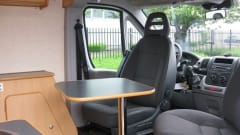 Compact bus camper with large fixed bed