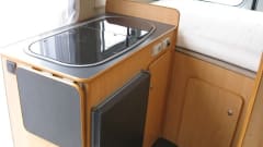 Compact bus camper with large fixed bed