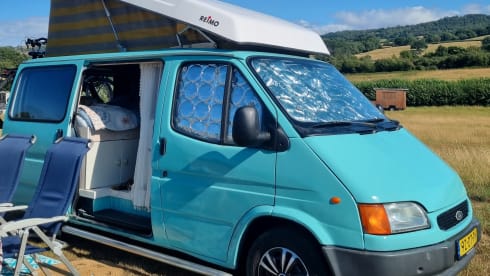 Retro turquoise camper, ready for a road trip. 