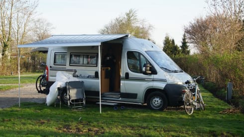 Compact bus camper with large fixed bed