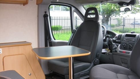 Compact bus camper with large fixed bed