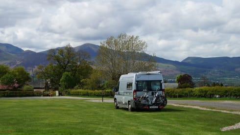 Compact bus camper with large fixed bed