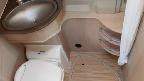 Bus camper with awning, private shower and toilet.