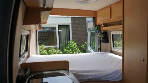 Compact bus camper with large fixed bed