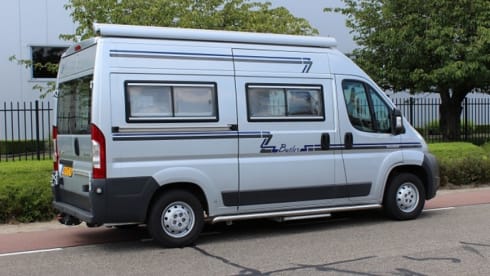 Compact bus camper with large fixed bed