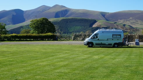 Compact bus camper with large fixed bed