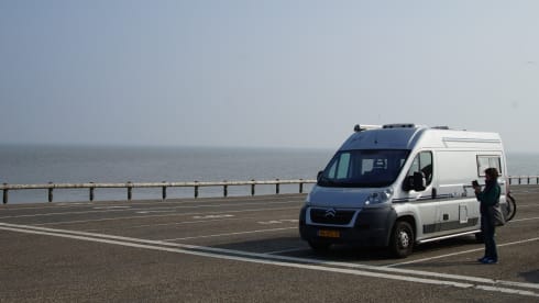 Compact bus camper with large fixed bed