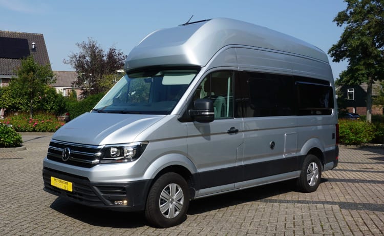 zeer stijlvolle en zeer nette VW Crafter Grand California uit 2020. Een bus camper met karakter, een ingenieuze indeling met comfort en een zeer nette grijs metallic kleur met stuurwielbediening en rondom parkeerhulp (sensoren). De VW Crafter Grand California heeft een 2.0 TDI motor met 177 PK. De Sandy B interieur Style bekleding en pilote stoelen geeft alle zitcomfort die past bij deze zeer doordacht als geriefelijk en comfortabele nette Bus camper.  De stijlvolle uitgeruste keukencenter heeft voldoende opbergmogelijkheden en is onder andere uitgerust met een 2-pits gasconform, Absorptie-koelkast, spoelbakafdekking. De bus is daarnaast voorzien van extra getinte ramen achter, elektrisch verstel- en verwarmbare buitenspiegels en een touchscreen centrale bedieningsunit.  De VW Crafter Grand California is verder onder meer uitgerust met:  Comfortline pakket van VW l Isofix l Cruise control incl. snelheidsbegrenzer l Start-stopsysteem met terugwinning l Centrale deurvergrendeling l Electrische ramen en spiegels l Trekhaak l Huishoudaccu l Cassette luifel l Standkachel  l Rondom parkeersensoren l Xenon koplampen met LED dagrijverlichting l Multifunctioneel lederen stuur l VW Multimediasysteem l Massasleutel hoofstroomschakelaar l Geïntegreerde blinderingen l Stoelen verwerkt in achterklep l    Chassis en Motor  De zuinig rijdende VW Crafter Grand California met een  2.0 TDI dieselmotor en 177 pk gecombineerd met een automatische versnellingsbak is zeer netjes en in goede staat. De camper is voorzien van nagenoeg nieuwe banden  – 3er Volkswagen Bus aus dem Jahr 2020