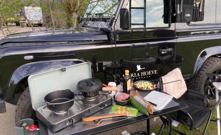 Landrover Defender magnificamente restaurato con tenda sul tetto.