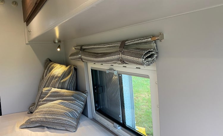 Buscamper Fiat Ducato met luxe stoelen en een groot 2 persoons bed.