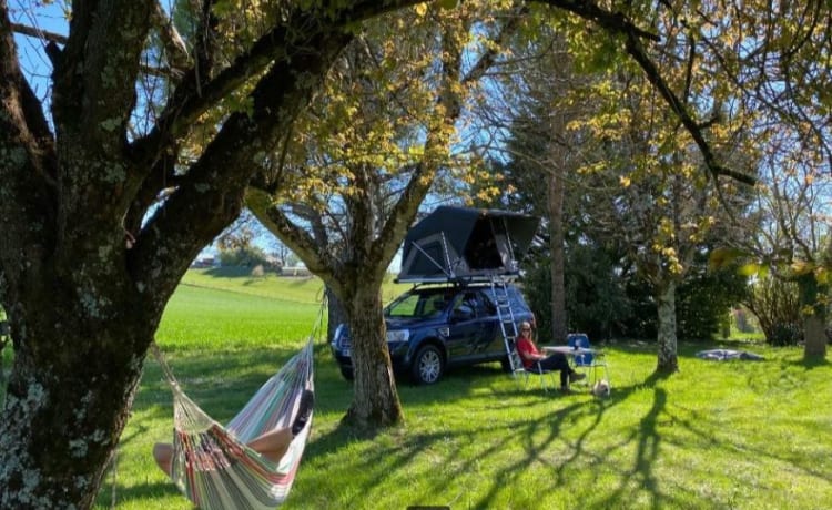 Mr. Blue Sky – Land Rover mit großem Dachzelt und voller Campingausrüstung in Frankreich