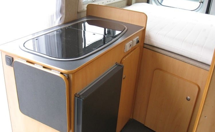 Compact bus camper with large fixed bed