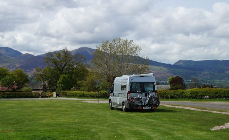 Compact bus camper with large fixed bed