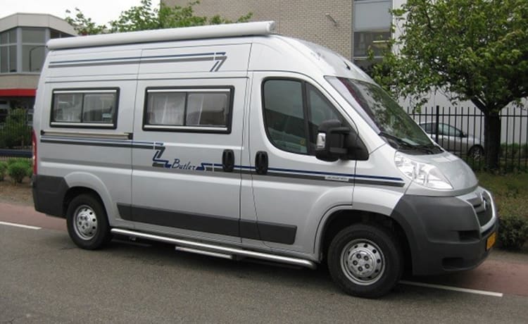 Compact bus camper with large fixed bed