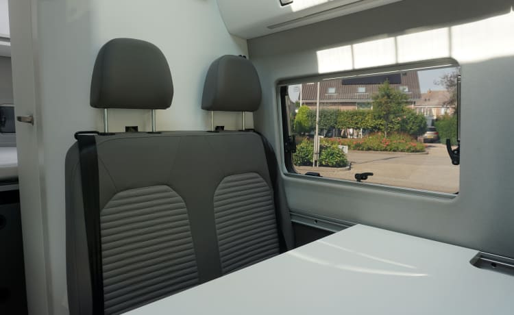 zeer stijlvolle en zeer nette VW Crafter Grand California uit 2020. Een bus camper met karakter, een ingenieuze indeling met comfort en een zeer nette grijs metallic kleur met stuurwielbediening en rondom parkeerhulp (sensoren). De VW Crafter Grand California heeft een 2.0 TDI motor met 177 PK. De Sandy B interieur Style bekleding en pilote stoelen geeft alle zitcomfort die past bij deze zeer doordacht als geriefelijk en comfortabele nette Bus camper.  De stijlvolle uitgeruste keukencenter heeft voldoende opbergmogelijkheden en is onder andere uitgerust met een 2-pits gasconform, Absorptie-koelkast, spoelbakafdekking. De bus is daarnaast voorzien van extra getinte ramen achter, elektrisch verstel- en verwarmbare buitenspiegels en een touchscreen centrale bedieningsunit.  De VW Crafter Grand California is verder onder meer uitgerust met:  Comfortline pakket van VW l Isofix l Cruise control incl. snelheidsbegrenzer l Start-stopsysteem met terugwinning l Centrale deurvergrendeling l Electrische ramen en spiegels l Trekhaak l Huishoudaccu l Cassette luifel l Standkachel  l Rondom parkeersensoren l Xenon koplampen met LED dagrijverlichting l Multifunctioneel lederen stuur l VW Multimediasysteem l Massasleutel hoofstroomschakelaar l Geïntegreerde blinderingen l Stoelen verwerkt in achterklep l    Chassis en Motor  De zuinig rijdende VW Crafter Grand California met een  2.0 TDI dieselmotor en 177 pk gecombineerd met een automatische versnellingsbak is zeer netjes en in goede staat. De camper is voorzien van nagenoeg nieuwe banden  – 3er Volkswagen Bus aus dem Jahr 2020