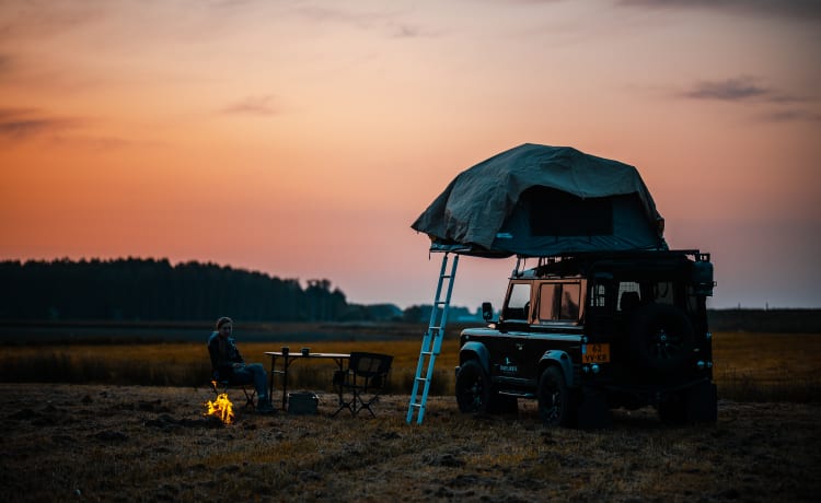 Beautifully restored Landrover Defender with roof tent.