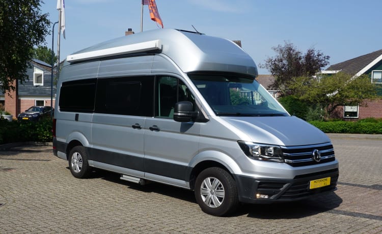 zeer stijlvolle en zeer nette VW Crafter Grand California uit 2020. Een bus camper met karakter, een ingenieuze indeling met comfort en een zeer nette grijs metallic kleur met stuurwielbediening en rondom parkeerhulp (sensoren). De VW Crafter Grand California heeft een 2.0 TDI motor met 177 PK. De Sandy B interieur Style bekleding en pilote stoelen geeft alle zitcomfort die past bij deze zeer doordacht als geriefelijk en comfortabele nette Bus camper.  De stijlvolle uitgeruste keukencenter heeft voldoende opbergmogelijkheden en is onder andere uitgerust met een 2-pits gasconform, Absorptie-koelkast, spoelbakafdekking. De bus is daarnaast voorzien van extra getinte ramen achter, elektrisch verstel- en verwarmbare buitenspiegels en een touchscreen centrale bedieningsunit.  De VW Crafter Grand California is verder onder meer uitgerust met:  Comfortline pakket van VW l Isofix l Cruise control incl. snelheidsbegrenzer l Start-stopsysteem met terugwinning l Centrale deurvergrendeling l Electrische ramen en spiegels l Trekhaak l Huishoudaccu l Cassette luifel l Standkachel  l Rondom parkeersensoren l Xenon koplampen met LED dagrijverlichting l Multifunctioneel lederen stuur l VW Multimediasysteem l Massasleutel hoofstroomschakelaar l Geïntegreerde blinderingen l Stoelen verwerkt in achterklep l    Chassis en Motor  De zuinig rijdende VW Crafter Grand California met een  2.0 TDI dieselmotor en 177 pk gecombineerd met een automatische versnellingsbak is zeer netjes en in goede staat. De camper is voorzien van nagenoeg nieuwe banden  – 3er Volkswagen Bus aus dem Jahr 2020