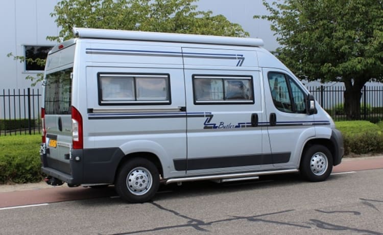 Compact bus camper with large fixed bed