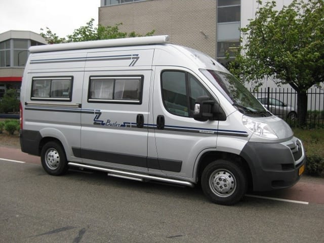 Compact bus camper with large fixed bed