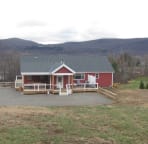 The rear of the home has a open and a covered deck with an access ramp