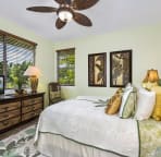 Main floor bedroom with queen bed decorated in a serene coconut palm motif.