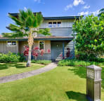Front view of villa with beautiful tea trees, palm and sea grape trees.