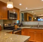 Fully equipped kitchen with stainless steel appliances, granite counters
