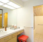 Two-room ensuite upstairs bathroom with makeup counter and stool